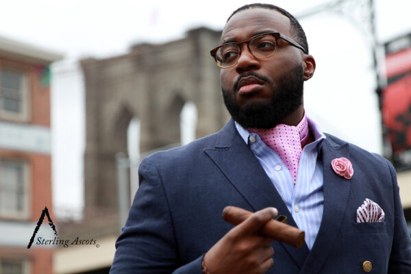 The Polka Dot Pink Sterling Ascot. The Look: Pink ascot, blue pinstripe shirt, navy blue double breasted blazer, Polka Dot Pink Sterling Pocket Square, pink lapel pin, and cigar. Shot in Brooklyn, NY. Only available at SterlingAscots.com